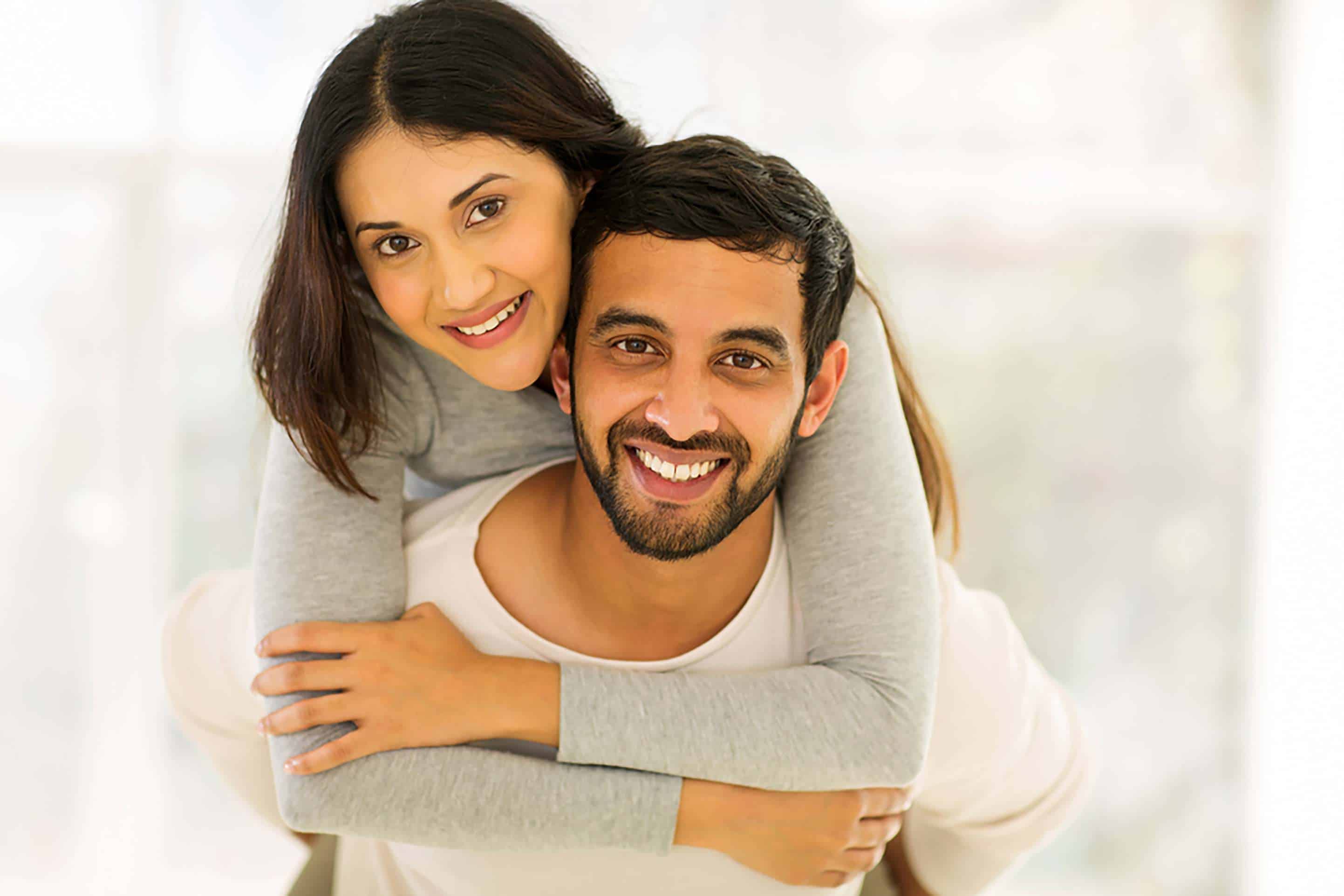Smiling South Asian couple posing together indoors